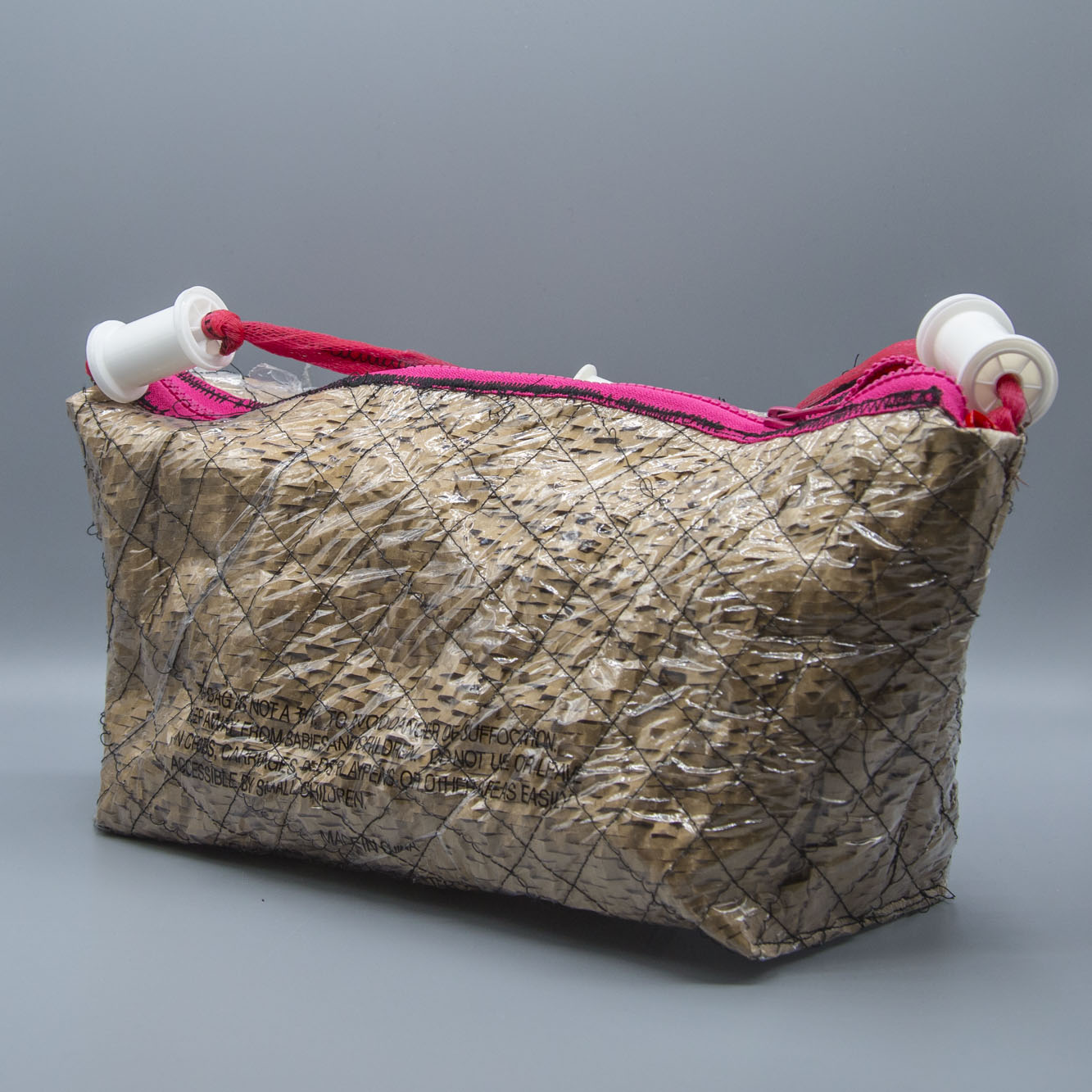 This purse is crafted from absorbent packaging wadding and plastic, reconceptualizing and transforming discarded materials into functional items while demonstrating a concern for trash pollution.